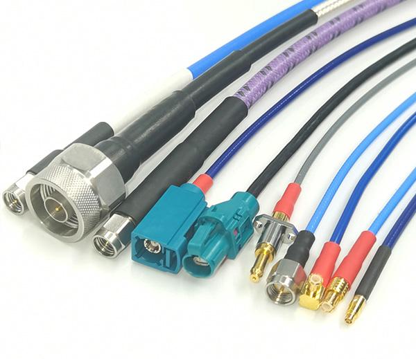 Custom RF cable assembly design process showing connector options, cable samples, and specification sheets on engineering desk